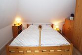 Doppelbett im offenen Wohn- und Essbereich